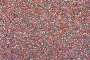 Wall decorated with small brown pebbles, background.