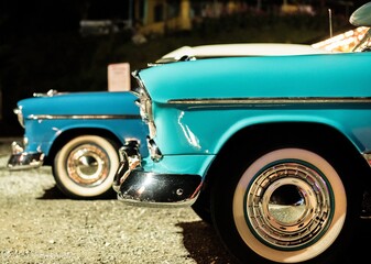 Closeup shot of a blue retro car with another old car in the background