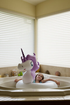 Girl&not;&dagger;(6-7) in unicorn shaped pool float in bathtub