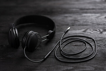 Best Headphones for Music. The headphones are dark in color against a wooden wall.