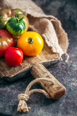 Fresh, ripe multi colored tomatoes on a dark background. Organic food.