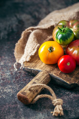Fresh, ripe multi colored tomatoes on a dark background. Organic food.