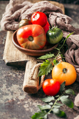Fresh, ripe multi colored tomatoes on a dark background. Organic food.
