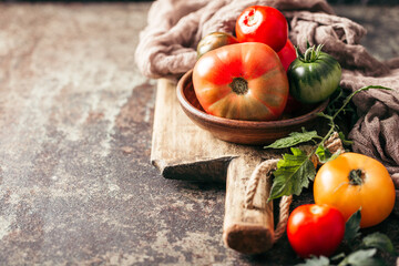 Fresh, ripe multi colored tomatoes on a dark background. Organic food.