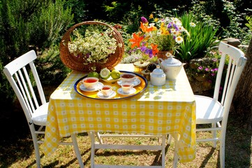 breakfast served on the white wooden table in a garden