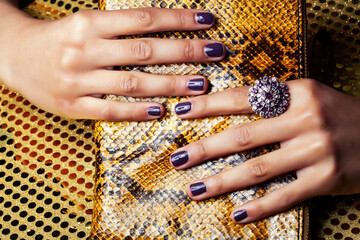pretty fingers of african american woman holding money closeup with purse, luxury jewellery on python clutch, cash for gifts