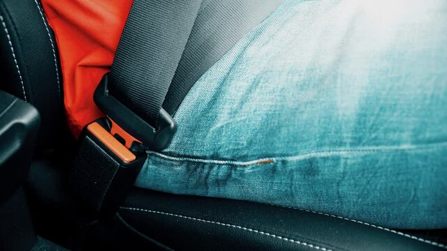 Man buckles up or fastens his seat belt. Road traffic safety related shot