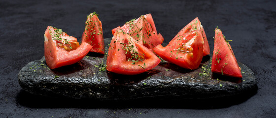 Healthy tomato cut with olive oil and herbs, typical food of the Mediterranean diet