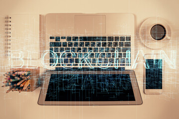 Blockchain theme hologram drawings over computer on the desktop background. Top view. Double...