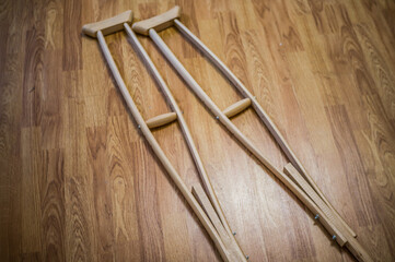 Wooden crutches on a wooden floor, for the movement of people with disabilities, people with fractures and sprains, or bone defects.