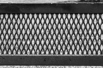 Grid pattern, weathered steel, metal. Black and white photo. 