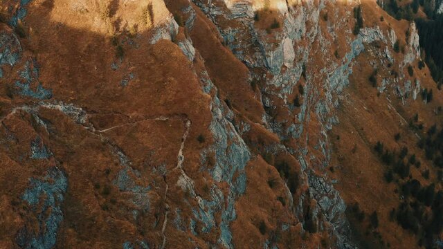 Aerial view over the mountain gorge. Video from drone flying over forested and cliffs slopes of mountains. Sunset time in Romania, travel background, 4k