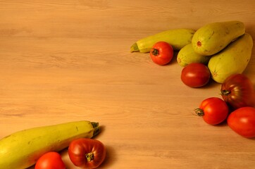 fresh natural zucchini and ripe tomatoes of different varieties from their own beds on a wooden table