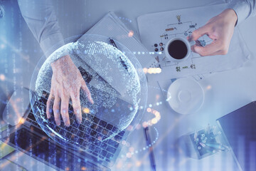 Multi exposure of man's hands typing over computer keyboard and world map hologram drawing. Top view. Technology concept.