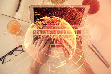 Double exposure of man's hands typing over computer keyboard and social network theme hologram drawing. Top view. People connection web concept.