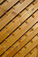 Brauner Lamellenzaun mit diagonalen Holzlatten