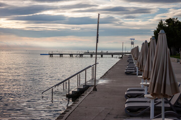 sunset at seaside empty beach and closed umbrellas