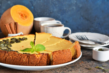 Homemade classic pumpkin cheesecake on a blue concrete background. Horizontal focus.