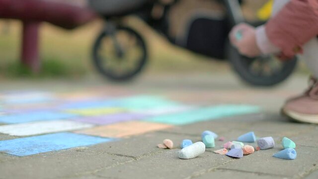 Selective focus. Woman with a child is painting. Daughter and mother are painting with chalk.