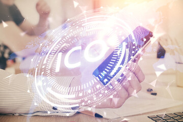 Double exposure of man's hands holding and using a phone and crypto currency blockchain theme drawing.