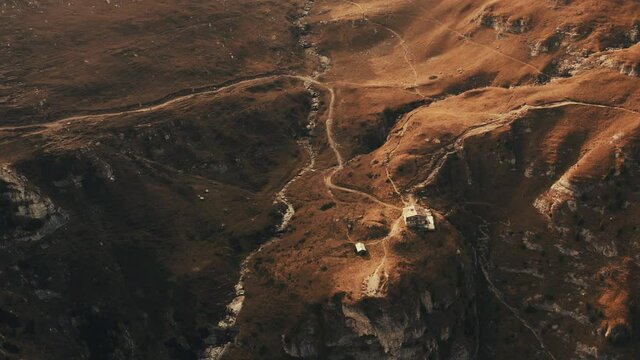 Aerial view on rocky peak mountains. Video from drone flying over valleys, forested and cliffs slopes of the mountain range. Sunset time in Romania, Majestic landscape, travel background, 4k