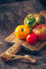 Fresh, ripe multi colored tomatoes on a dark background. Organic food.