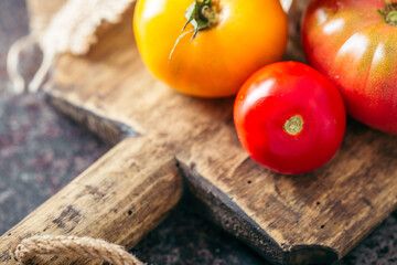 Fresh, ripe multi colored tomatoes on a dark background. Organic food.