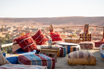 Afwasbaar Fotobehang Marokko Old lamp on table with cushions over rooftop restaurant against clear sky