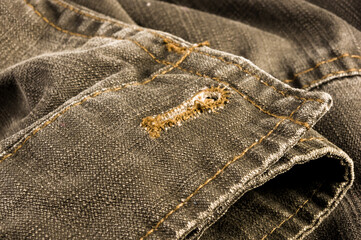 clothing items stonewashed cotton fabric texture with seams, clasps, buttons and rivets, macro