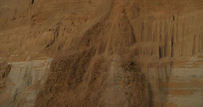 Sexy lady tramples on the edge of a cliff. collapse of sand. A pretty girl is standing on the edge of a sand dune with a snowboard or sandboard. Mountain relaxation. Concept of freedom, lifestyle.