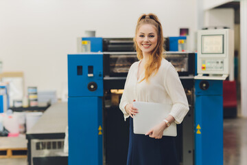 Young woman working in printing factory. Printing Press.