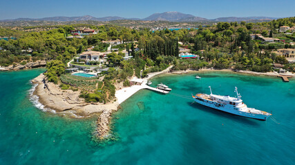 Obraz premium Aerial drone photo of Chinitsa bay a popular anchorage crystal clear turquoise sea bay for yachts and sail boats next to Porto Heli, Saronic gulf, Greece