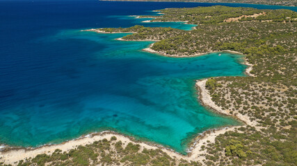 Fototapeta na wymiar Aerial drone photo of beautiful fjord landscape forming turquoise beaches in small vegetated coves in Porto Heli a popular anchorage for yachts and sail boats, Argolida, Greece