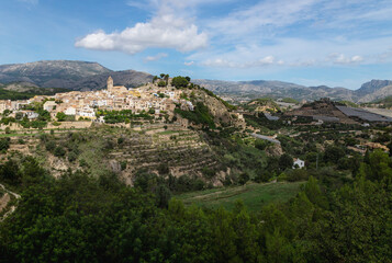 Fototapeta na wymiar Panorama view of the hills of Polop de Marina with church and castell over green forest at the Costa Blanca, Spain