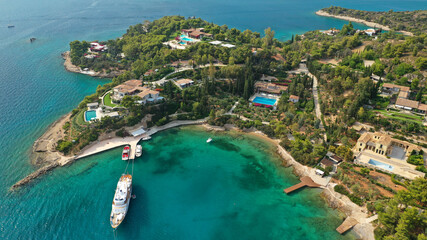 Fototapeta na wymiar Aerial drone photo of Hinitsa bay a popular anchorage crystal clear turquoise sea bay for yachts and sailboats next to Porto Heli, Saronic gulf, Greece
