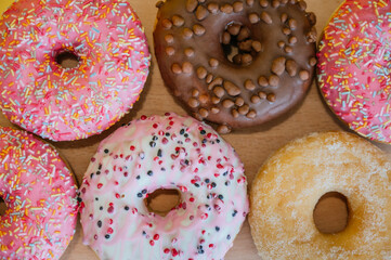 Top view of variety of donuts on a wooden table