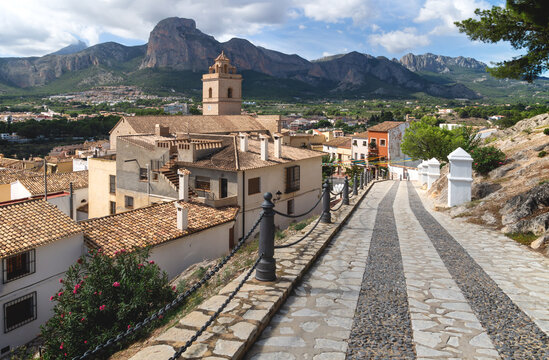 Cobbled street to church of Polop de Marina with mountainrange, Costa Blanca, Spain