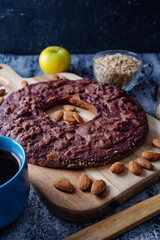 Front view of a delicious homemade fruits bagel in a wooden table. Made of apples, blackberries and almonds using only oats.