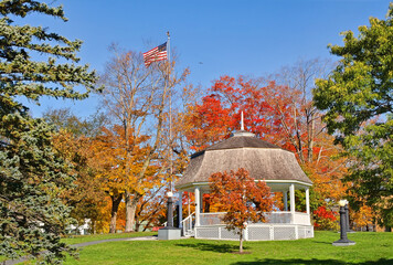 White gazebo surrounded by autumn colors in a city park in New England - Powered by Adobe