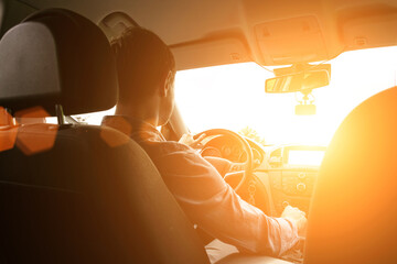 Road trip. Happy young man have fun travel inside car at sunset. Summer vacation concept with...