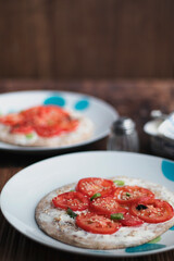 Homemade pizza with tomatoes plates served in a wooden table