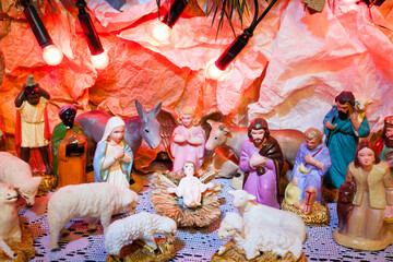 Nativity scene with colorful figurines of holy Mary Joseph Three Kings and animals symbolize Jesus place of birth Bethlehem crib	