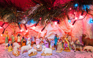 Naklejka premium Nativity scene with colorful figurines of holy Mary Joseph Three Kings and animals symbolize Jesus place of birth Bethlehem crib 