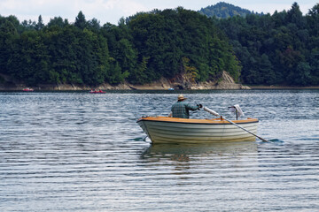 Fototapeta na wymiar Man fishing at lake. Fisherman on boat.