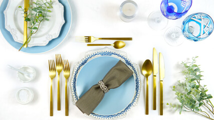 Elegant fine china events table place settings in blue white and gold theme overhead for weddings, Christmas, birthdays, Thanksgiving or Valentine's Day. Top view creative composition flat lay.