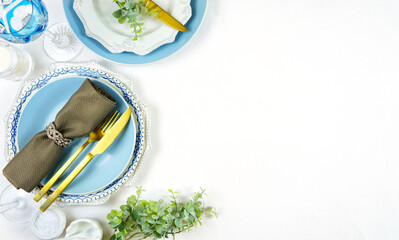 Elegant fine china events table place settings in blue white and gold theme overhead for weddings, Christmas, birthdays, Thanksgiving or Valentine's Day. Top view flat lay with negative copy space.