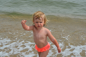 caucasian child 2 years old with blond hair outdoor in summer lifestyle on the beach