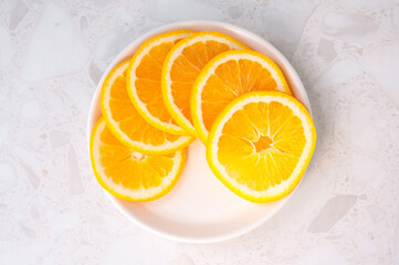 Plate with round pieces of juicy orange on the table, top view