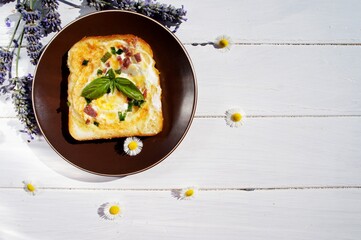 fried egg in the toast on white wood background