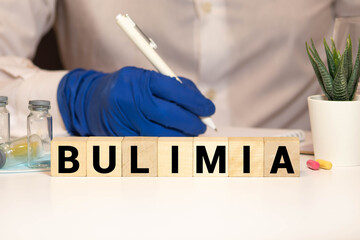 Bulimia word from wooden blocks on desk - obrazy, fototapety, plakaty